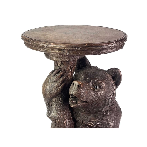 1 - A Black Forest Linden wood carved bear stand. 19th century, with inset glass eyes and supporting a t... 