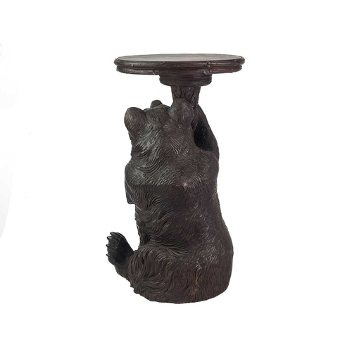 1 - A Black Forest Linden wood carved bear stand. 19th century, with inset glass eyes and supporting a t... 