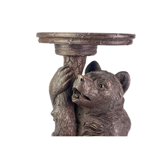 1 - A Black Forest Linden wood carved bear stand. 19th century, with inset glass eyes and supporting a t... 