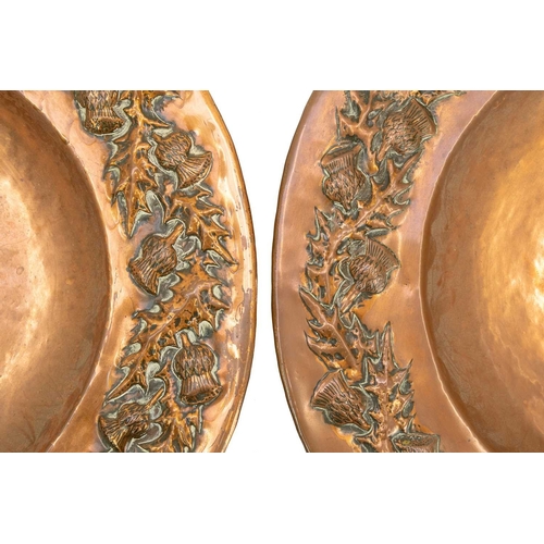 119 - A pair of Scottish arts and crafts copper chargers. With thistle design repousse decoration, both ar... 