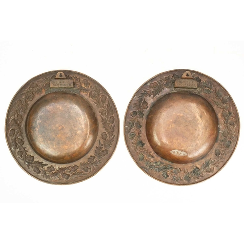 119 - A pair of Scottish arts and crafts copper chargers. With thistle design repousse decoration, both ar... 