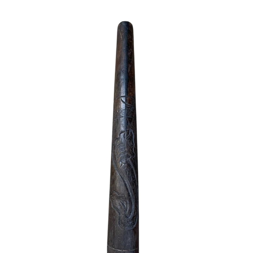 16 - An Australian carved hardwood didgeridoo. Decorated with bird and floral motifs, length 125cm.