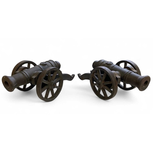 162 - A pair of heavy cast iron models of cannon. Each with a wheeled carriage, length 33cm, together with... 