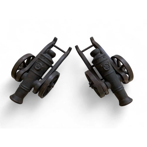 162 - A pair of heavy cast iron models of cannon. Each with a wheeled carriage, length 33cm, together with... 