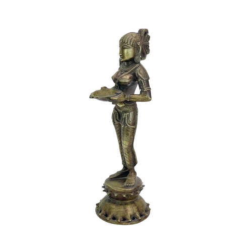 184 - An Indian bronze Lakshmi figure. 20th-century, holding a bowl for incense, standing on a lotus flowe... 