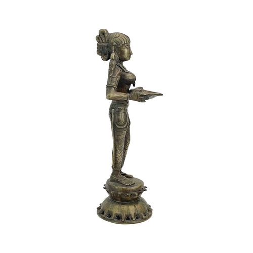 184 - An Indian bronze Lakshmi figure. 20th-century, holding a bowl for incense, standing on a lotus flowe... 