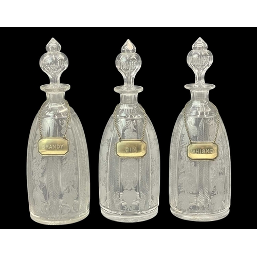 185 - A set of three Victorian engraved glass decanters and stoppers. With plated labels, height 37cm, tog... 