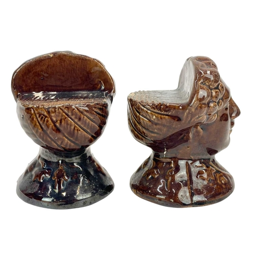 230 - A pair of early Victorian treacle glaze sash window stops. Of bust form, height 11cm.