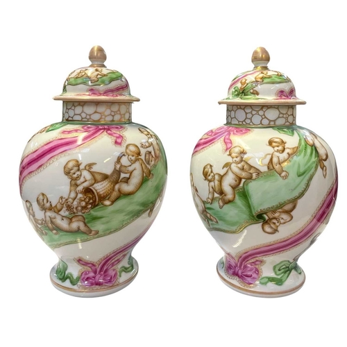 234 - A pair of Helena Wolfsohn porcelain vases and covers. Circa 1900, with cherubs cavorting on pink and... 