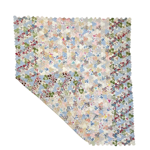 291 - A hand-sewn patchwork quilt. Early 20th century, featuring hexagons of lightweight cotton, no edging... 