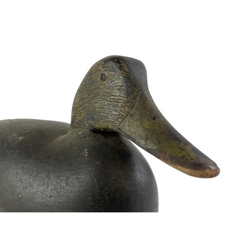 296 - An American black painted hollow duck decoy. Early 20th century, the lead weight with a copper plaqu... 