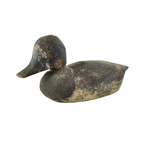 307 - An American carved pine duck decoy. Early 20th century, with a broad painted body, length 31cm, toge... 