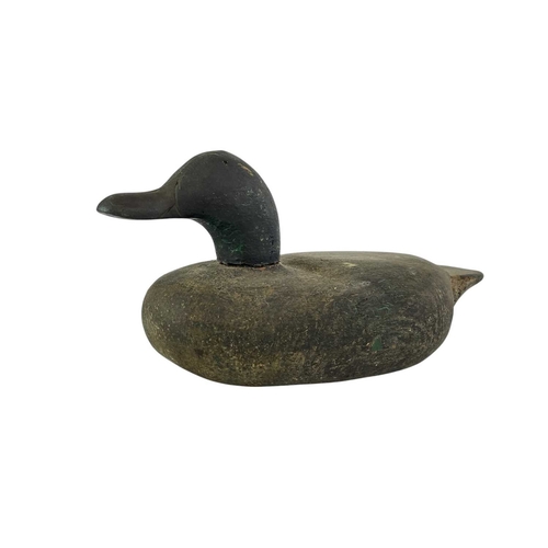 307 - An American carved pine duck decoy. Early 20th century, with a broad painted body, length 31cm, toge... 