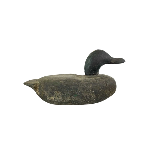 307 - An American carved pine duck decoy. Early 20th century, with a broad painted body, length 31cm, toge... 