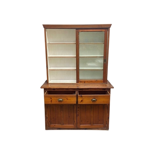 308 - A stained pine kitchen dresser. The top with two glazed sliding doors, the base fitted two drawers a... 