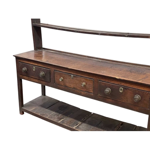 310 - A George III oak dresser and rack. Fitted two shelves above three drawers and with a pot board below... 