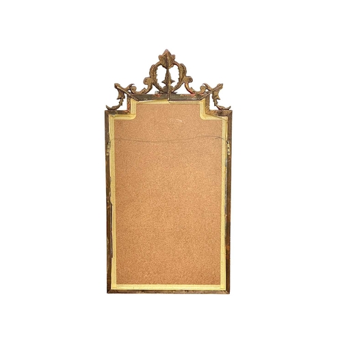 324 - A carved giltwood wall mirror. Late 19th century, with a stepped rectangular plate, leaf and scroll ... 