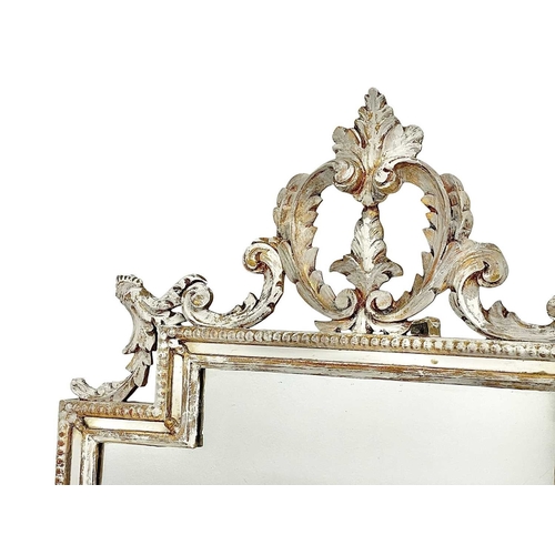 324 - A carved giltwood wall mirror. Late 19th century, with a stepped rectangular plate, leaf and scroll ... 