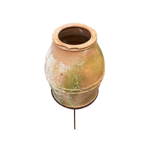 334 - A terracotta olive jar on a stand. With banded decoration, height 80cm, width 34cm.