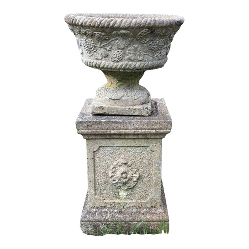 348 - A pair of reconstituted stone garden urns on separate plinths. With moulded floral decoration, overa... 