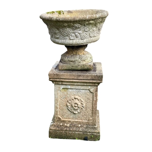 348 - A pair of reconstituted stone garden urns on separate plinths. With moulded floral decoration, overa... 