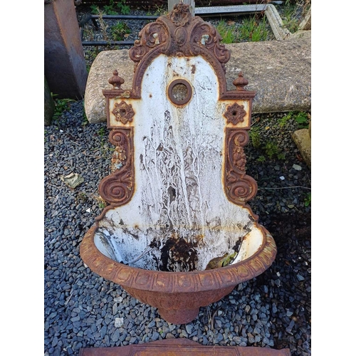 351 - A cast iron wall fountain. Height 75cm together with a cast iron fireback fragment. (2)