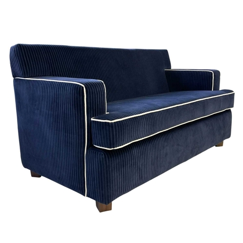 398 - ± Superyacht furnishings, a contemporary two-seater blue sofa. Upholstered in a chunky retro navy bl... 