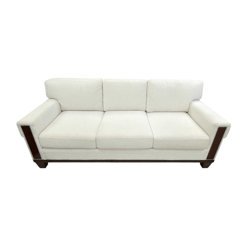 424 - ± Superyacht furnishings, a contemporary three/four seater sofa with white boucle fabric. On a highl... 