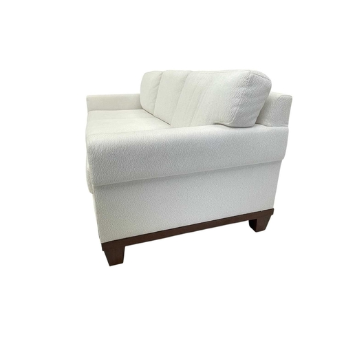 424 - ± Superyacht furnishings, a contemporary three/four seater sofa with white boucle fabric. On a highl... 