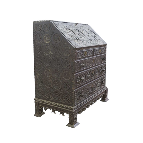 434 - An oak bureau. Early 18th century, with later ornate carved decoration of interior scenes, flowers a... 