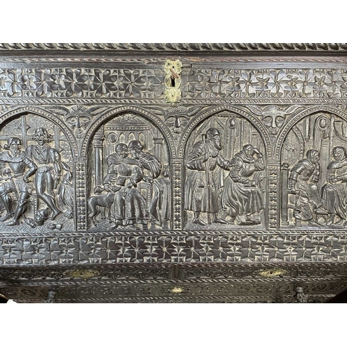 434 - An oak bureau. Early 18th century, with later ornate carved decoration of interior scenes, flowers a... 