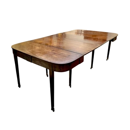 436 - A late George III mahogany concertina action dining table. With D-shaped end sections, on tapered le... 