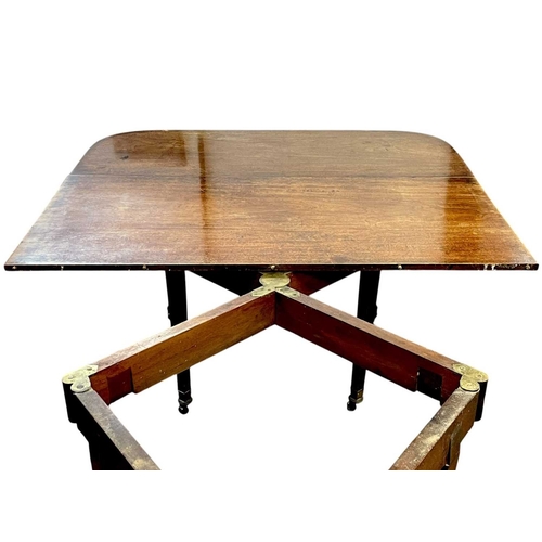 436 - A late George III mahogany concertina action dining table. With D-shaped end sections, on tapered le... 