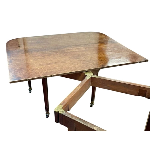 436 - A late George III mahogany concertina action dining table. With D-shaped end sections, on tapered le... 