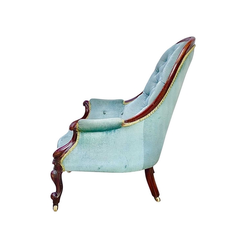 437 - A Victorian mahogany show frame button back armchair. Raised on cabriole front legs and porcelain ca... 