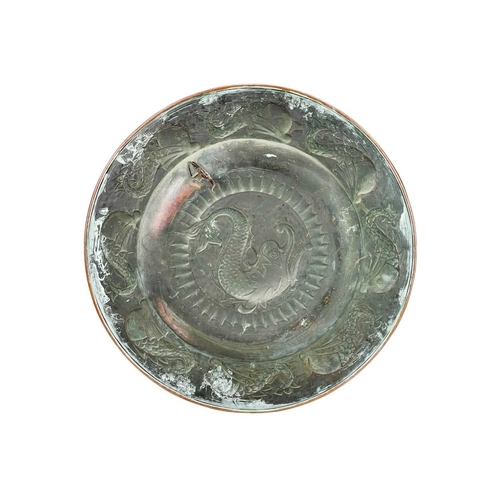 44 - A J. & F. Pool, Hayle copper charger. Repousse decorated with a stylised dolphin to the centre and f... 