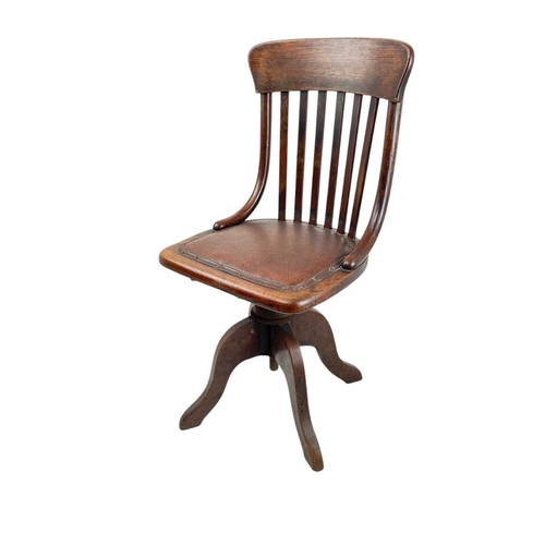 443 - An Edwardian oak office or typist's chair. With slat back and swivel seat, on four feet, height 88cm... 