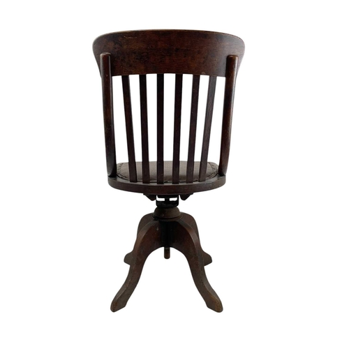 443 - An Edwardian oak office or typist's chair. With slat back and swivel seat, on four feet, height 88cm... 