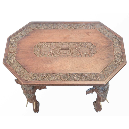 451 - A carved hardwood table with Indian elephant head decoration. Features an intricately carved octagon... 