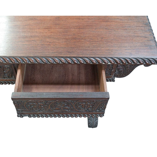 454 - A George IV Anglo Indian Padouk library table. The rectangular top with a gadrooned edge above two d... 