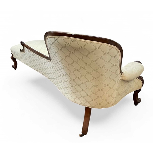 467 - A Victorian mahogany framed chaise longue. With a button upholstered spoon back, and raised on carve... 