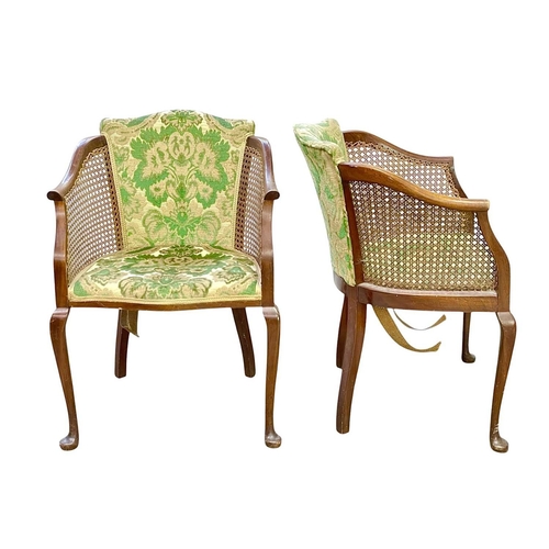 472 - A pair of mahogany bergere tub chairs. Circa 1920, with floral velour seats and backs, cane sides an... 