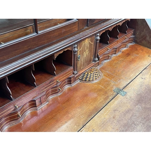 502 - A George III mahogany bureau and bookcase. The upper part with two glazed doors, the lower part with... 