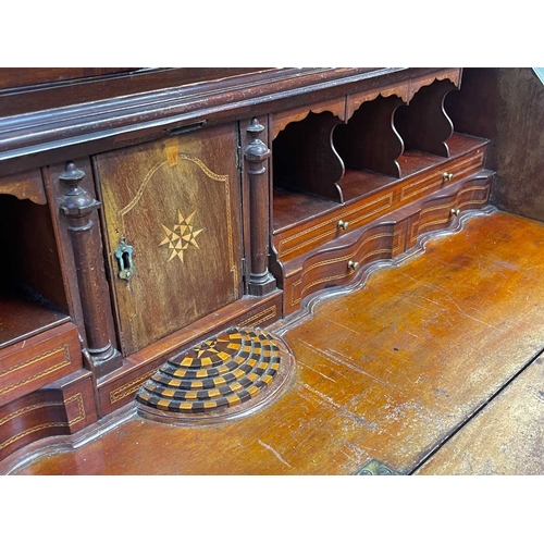 502 - A George III mahogany bureau and bookcase. The upper part with two glazed doors, the lower part with... 