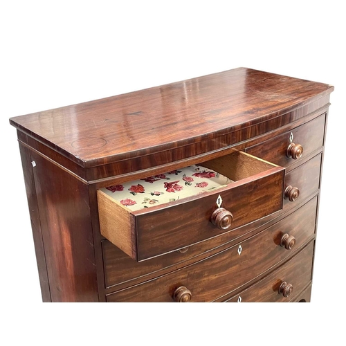 509 - A late George III mahogany bow front chest. Fitted two short and three long drawers, with turned kno... 