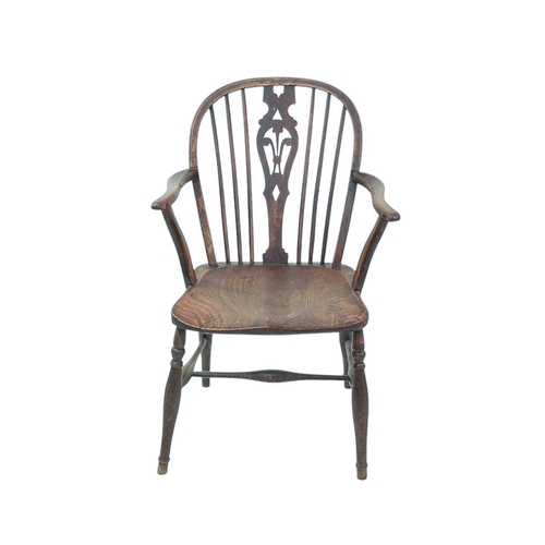 519 - An ash and elm Windsor armchair. 19th century, the central splat pierced with Fleur-De-Lys, the arms... 