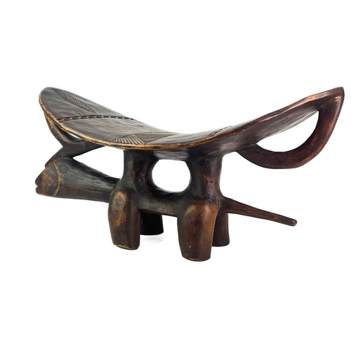 57 - An African hardwood zoomorphic stool. With a carved dished top, and shell inlaid eyes, height 29cm, ... 