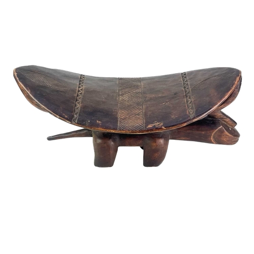 57 - An African hardwood zoomorphic stool. With a carved dished top, and shell inlaid eyes, height 29cm, ... 