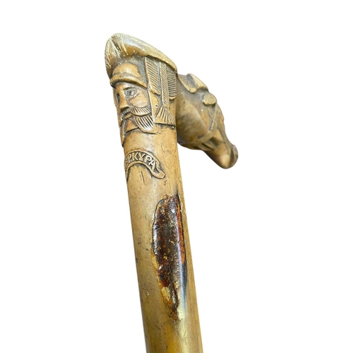 6 - A Greek carved cane. Made from olive wood, the handle formed as a horse's head, with a bearded male ... 