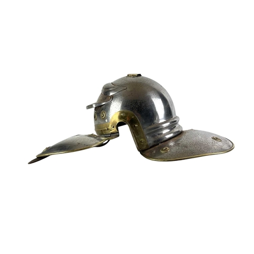 64 - A painted and brass mounted bulkhead wall clock and a Roman style helmet. The former with a white en... 